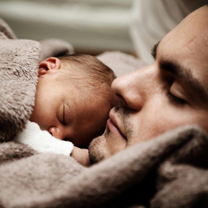 A Touching Close Up Of A Father And His Baby Peacefully Napping Together.