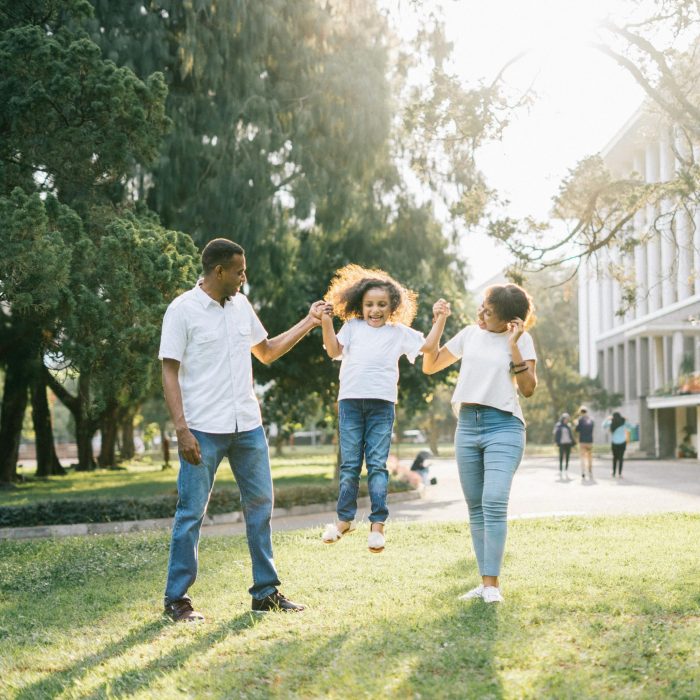 Joyful Family Enjoying A Playful Day At The Park, Embracing Love And Togetherness Under The Summer Sun.