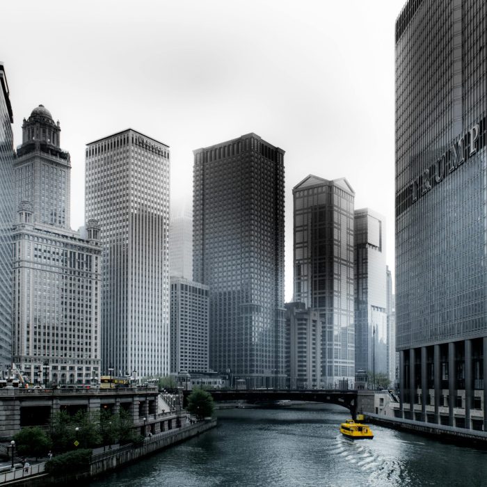 Stunning View Of Chicago's Skyscrapers Along The River With A Yellow Water Taxi.