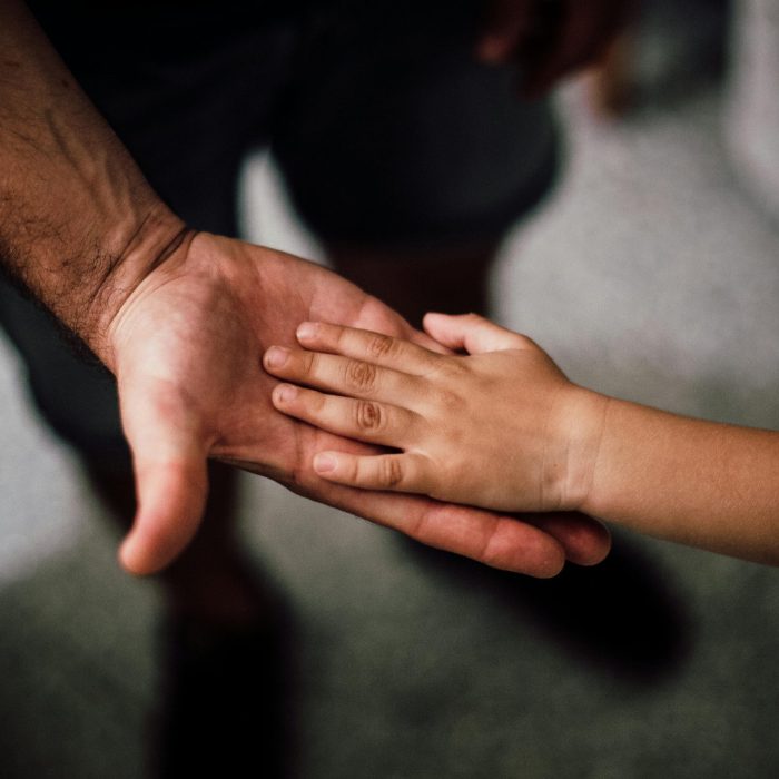 Close Up Of A Child's Hand Resting Gently On A Man's Hand, Symbolizing Love And Support.