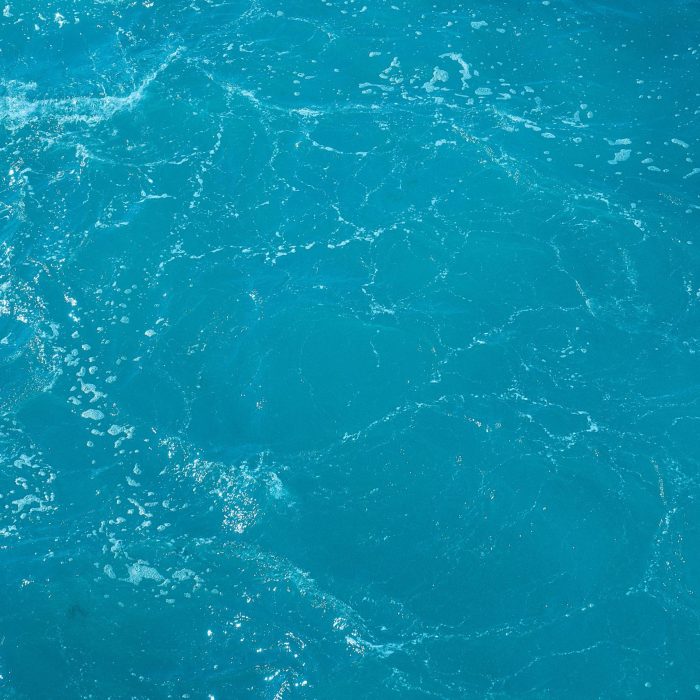 A Detailed And Vibrant View Of Turquoise Ocean Water With Light Reflections.