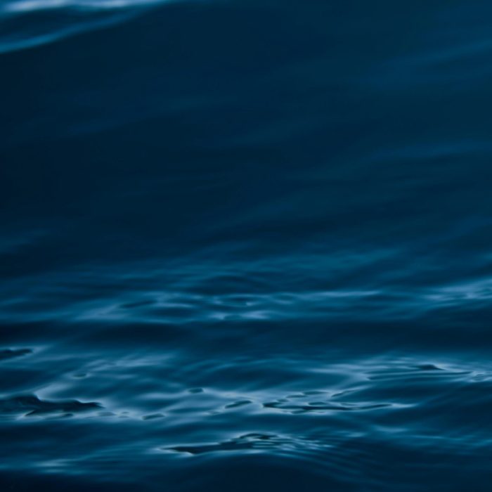 A Tranquil View Of Dark Blue Ocean Waves With Gentle Ripples And Motion.