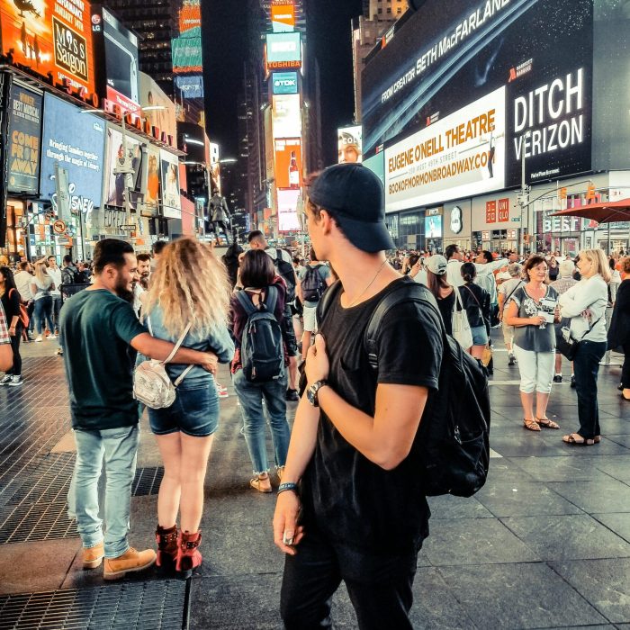 Bustling Scene In Times Square, New York City Showcasing The Vibrant Nightlife And Diverse Crowd.