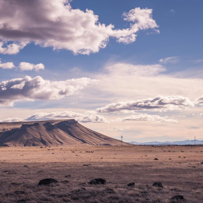 Serene View Of A Dry, Mountainous Landscape Under A Cloudy Sky.