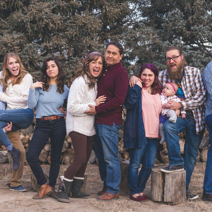 A Joyful Family Poses Together Outdoors During A Fall Day, Expressing Love And Happiness.