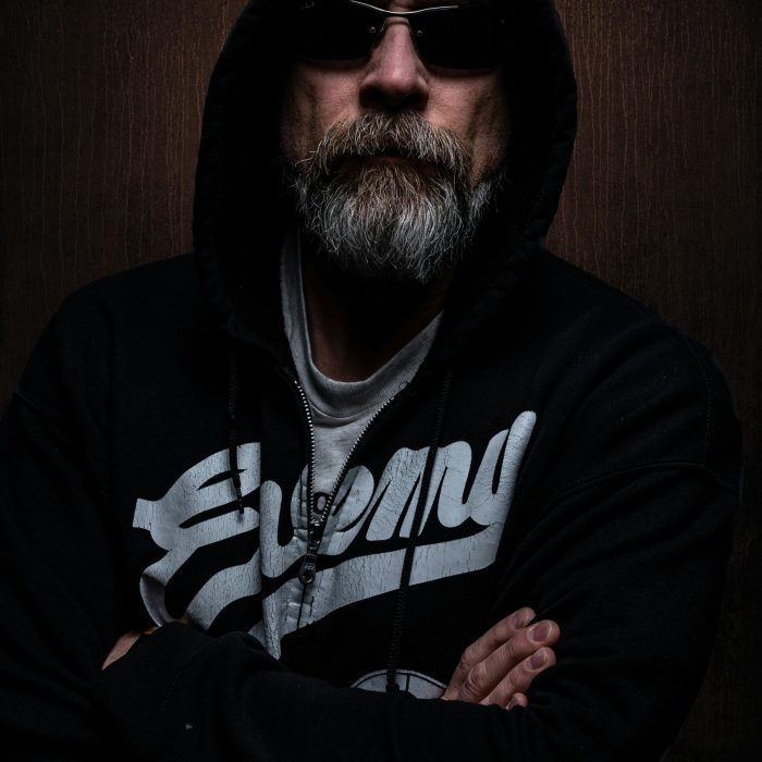 Portrait Of A Bearded Man In A Dark Hoodie And Sunglasses, Exuding Mystery.