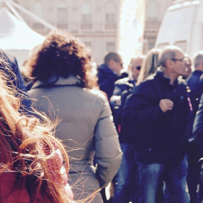 A Lively Group Of People Gathers In An Outdoor Setting During Daytime.