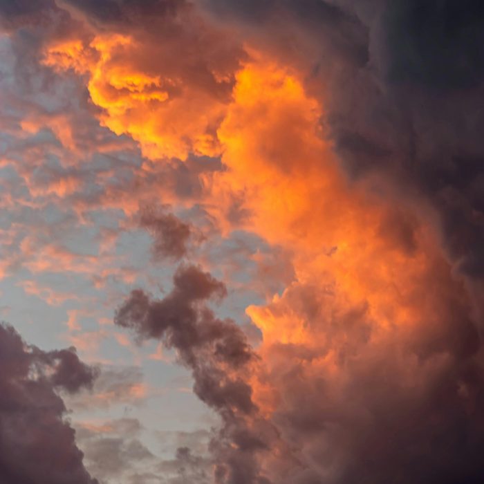 Captivating Cloud Formation At Sunset Showcasing Vibrant Orange And Dark Clouds.