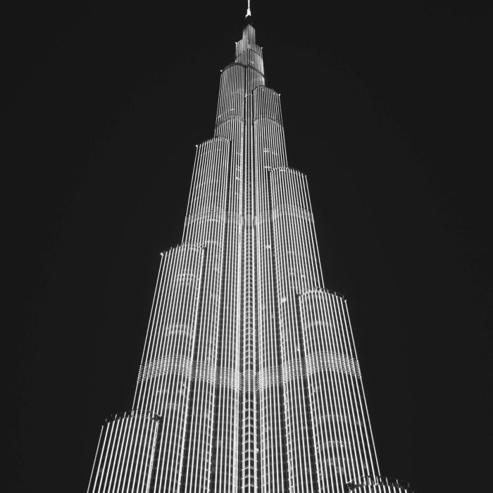 Black And White Photo Of Burj Khalifa At Night, Showcasing Its Striking Architecture Against The Sky.