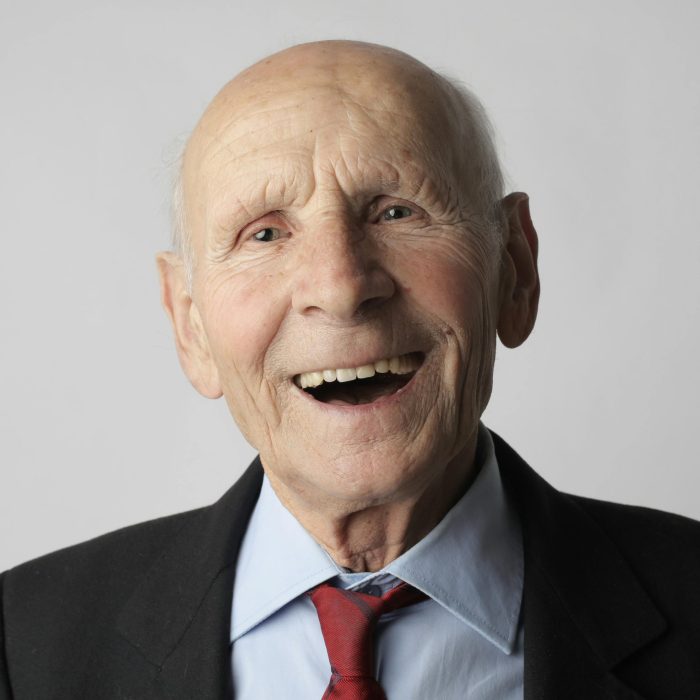 A Smiling Elderly Man In A Suit And Tie, Conveying Happiness And Wisdom.