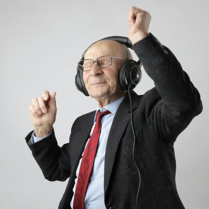 Senior Man Enjoying Music With Headphones, Expressing Happiness And Energy.