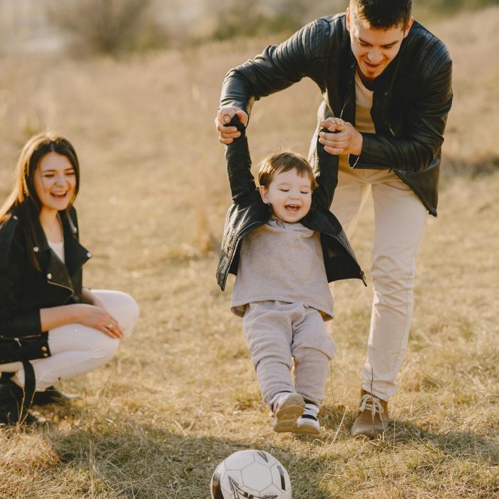 Family Enjoying Playful Soccer Game Outdoors, Capturing Joyful Moments.