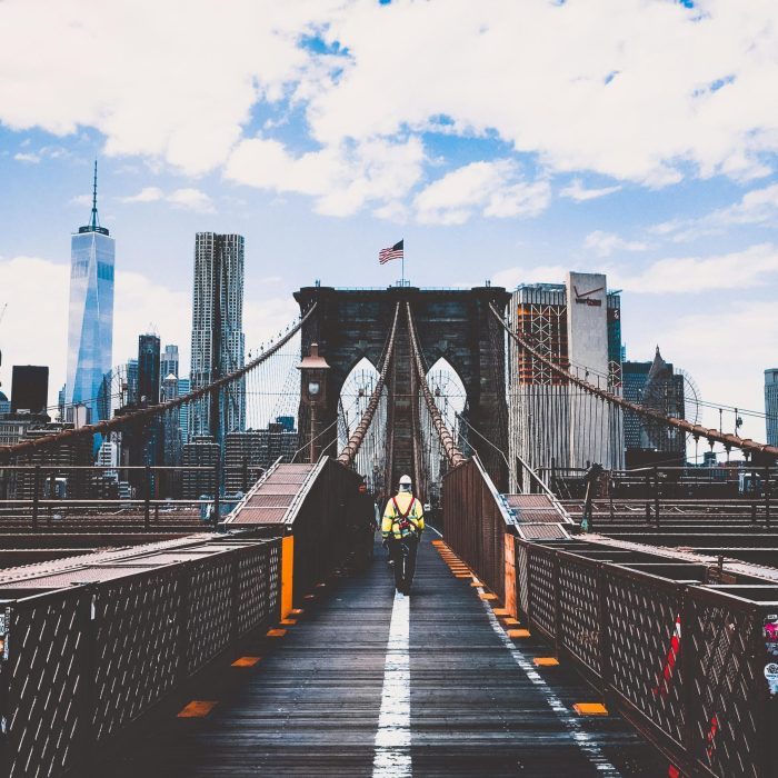 Iconic Brooklyn Bridge View With New York City Skyline And Construction Worker.