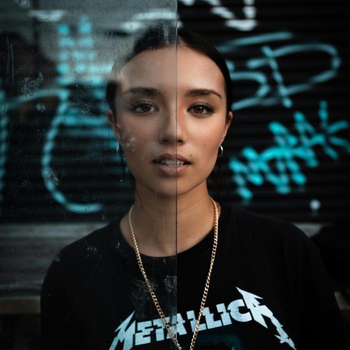 Dramatic Portrait Of A Young Woman With Graffiti, Showcasing Urban Style.