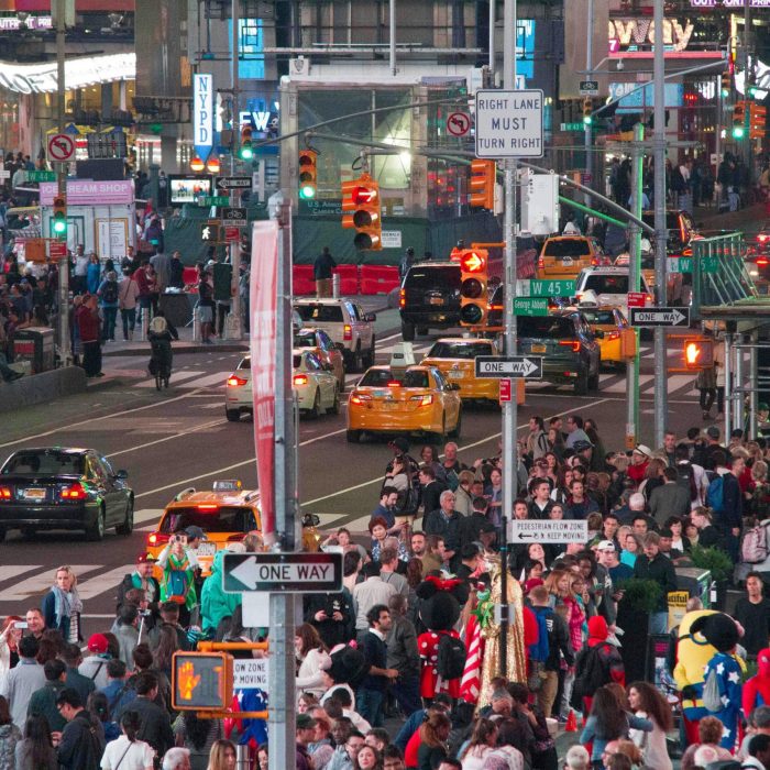 A Vibrant Night Scene In Times Square, New York City, Filled With Crowds And Traffic.