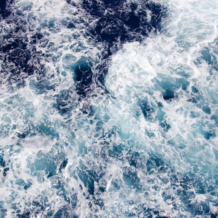A Dramatic View Of Swirling Ocean Waves Captured From Above, Showcasing The Beauty Of Maritime Motion.