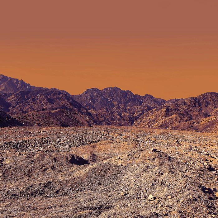 Stunning Landscape Of South Sinai's Rocky Desert Under A Vibrant Orange Sky.