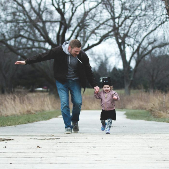 Dad And Daughter Enjoying A Walk In The Park, Symbolizing Love And Togetherness.